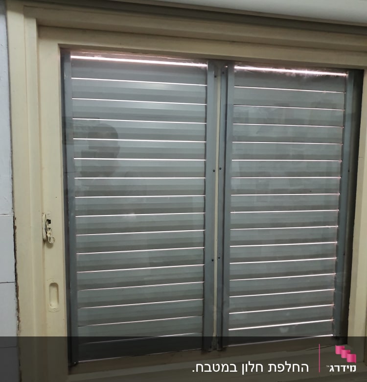 חלון עם תריסים סגורים ומסגרת עץ